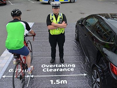 Overtaking clearance is 1.5 meters, Cyclist kirb side, police officer and then car.
